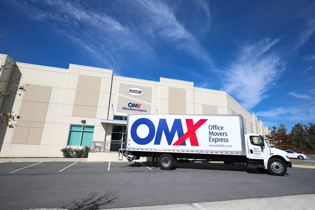 OMX truck in front of building